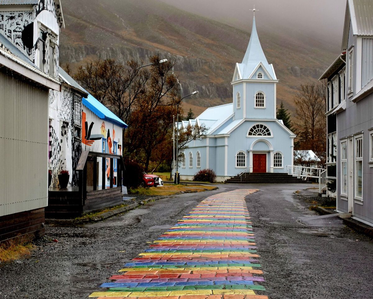 rainbow street leading up to a church in Seydisfjordur iceland